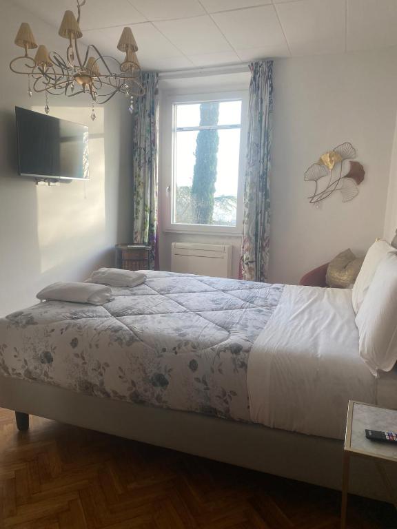 Suite Margherita: camera matrimoniale con lampadario e vista sui cipressi
