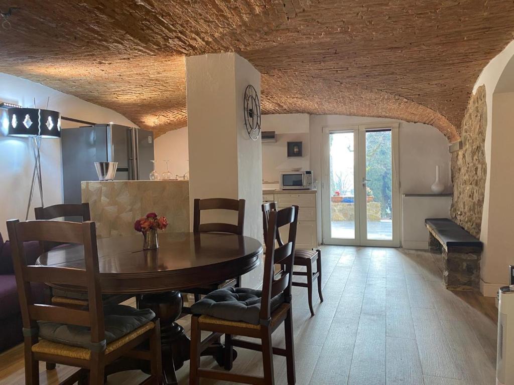 Soggiorno con soffitto a volte in mattoni e tavolo da pranzo