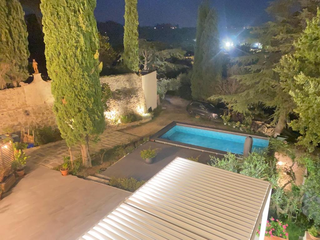 Vista notturna sulla piscina e sul giardino de Il Portico di Margherita, con le luci di Firenze sullo sfondo