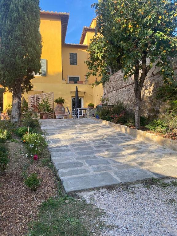 Facciata della villa toscana del 1600 con vialetto in pietra e alberi di limone